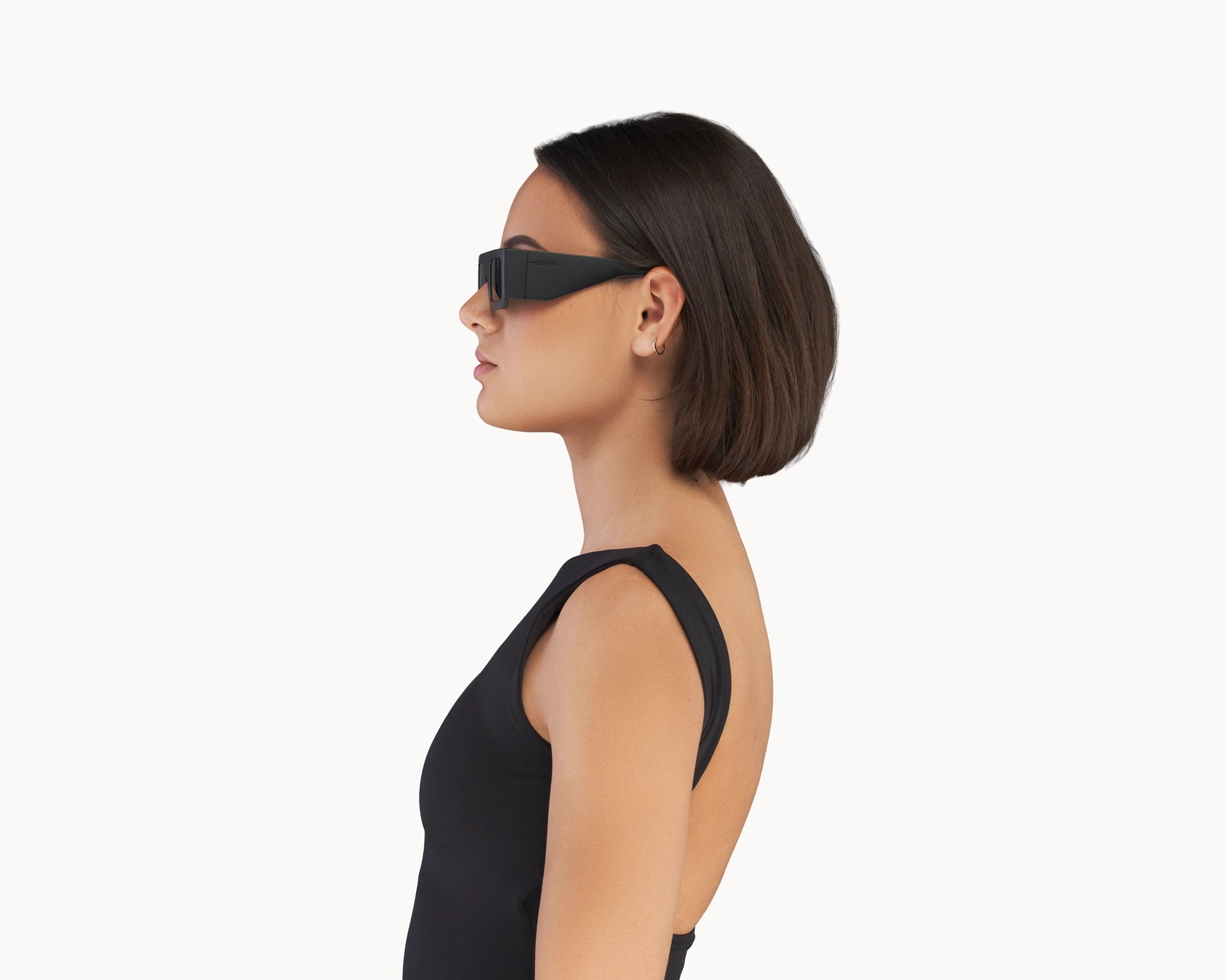 Kvinnelig modell med ikoniske 3D-inspirerte sorte retro-solbriller fra VIDAR EYEWEAR.