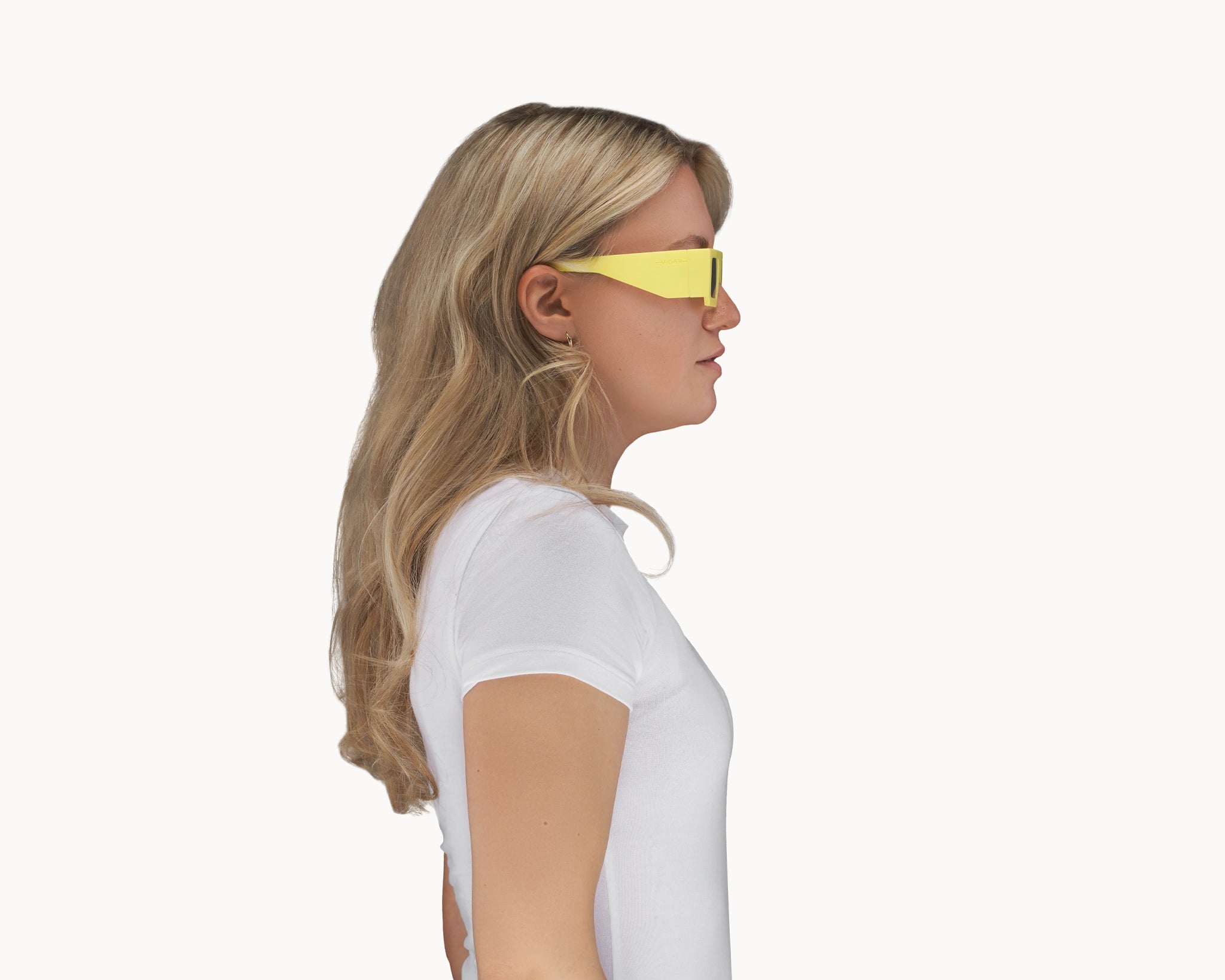 Kvinnelig modell med ikoniske 3D-inspirerte gule retro-solbriller fra VIDAR EYEWEAR.