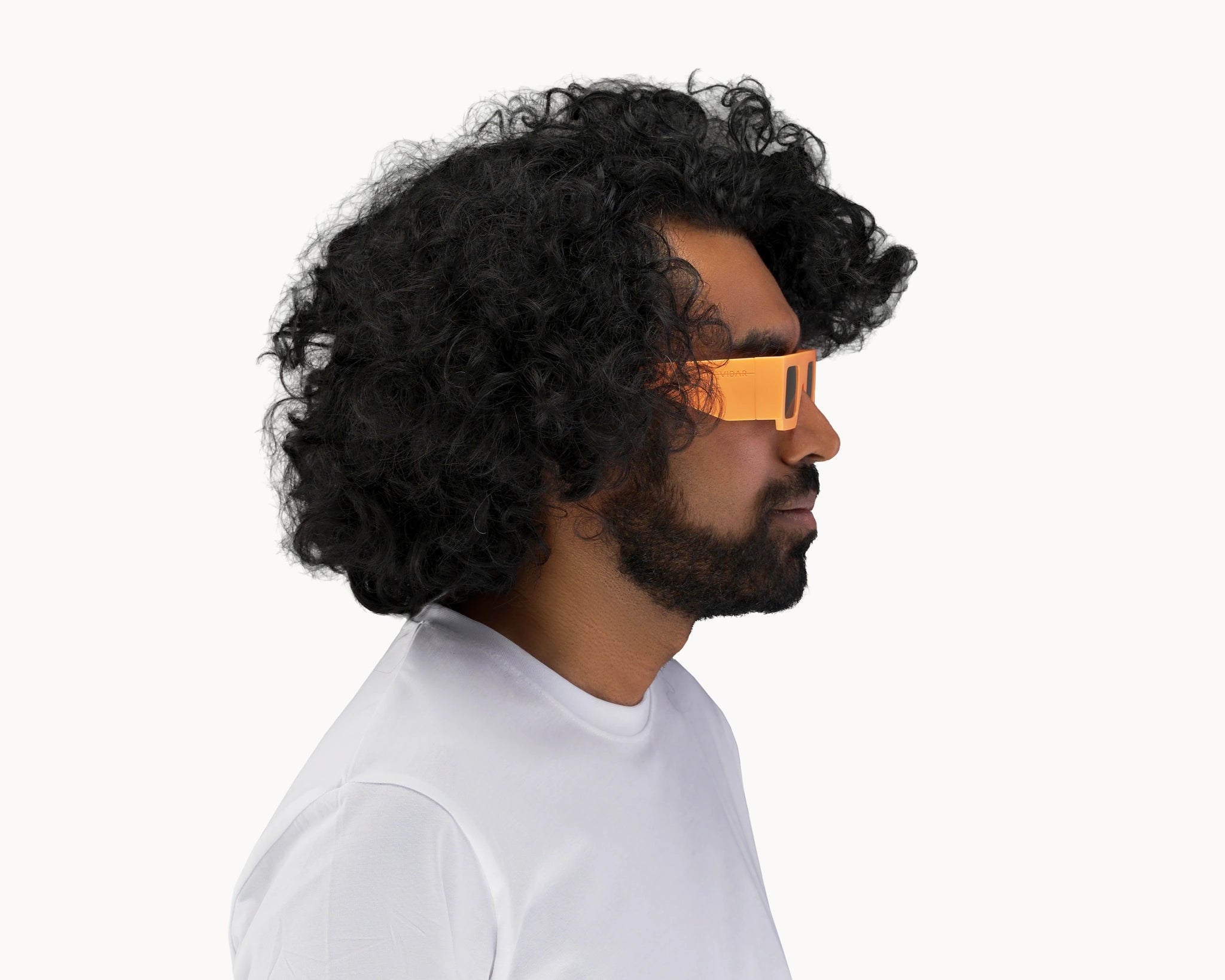 Kvinnelig modell med ikoniske 3D-inspirerte oransje retro-solbriller fra VIDAR EYEWEAR.