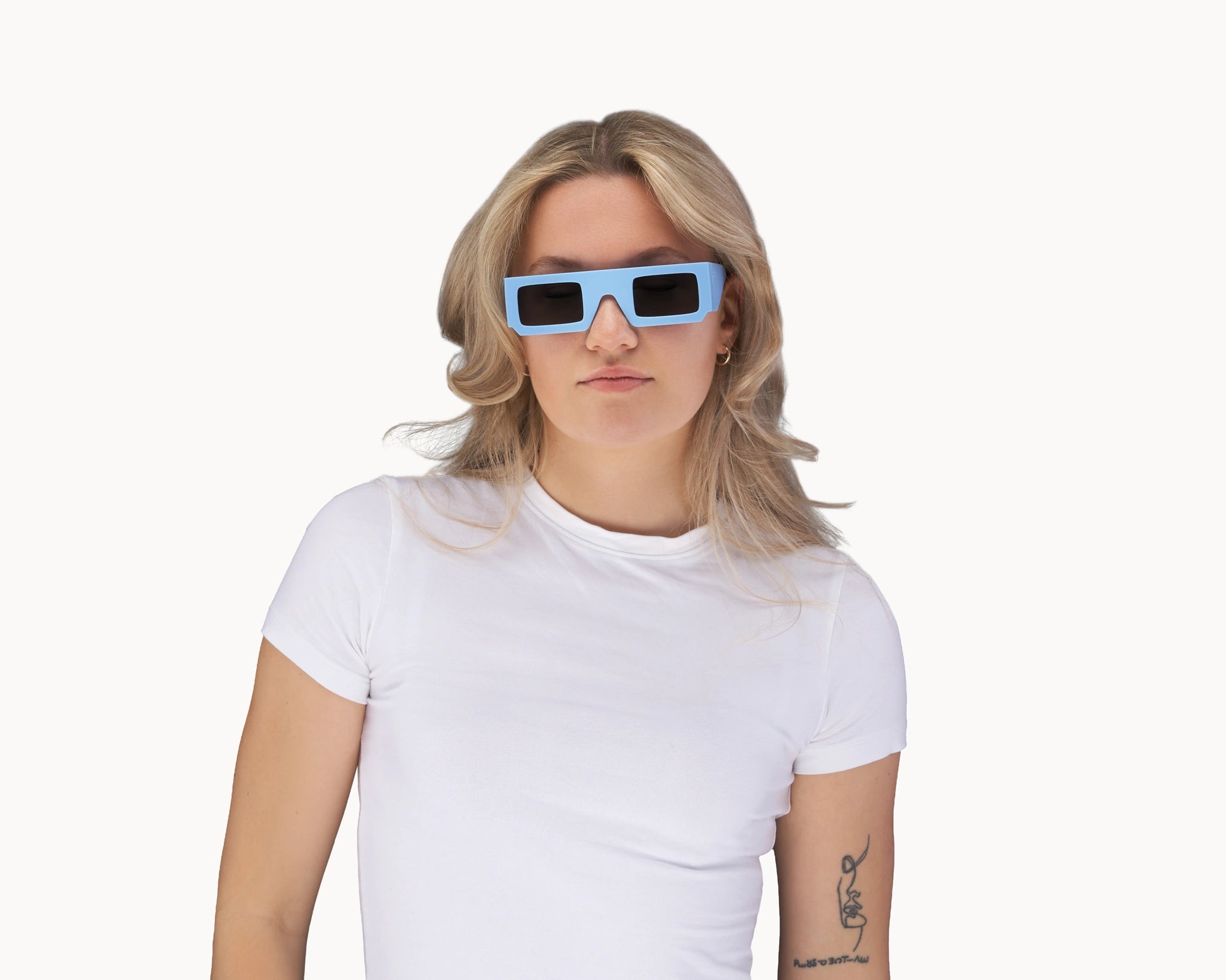 Kvinnelig modell med ikoniske 3D-inspirerte blå retro-solbriller fra VIDAR EYEWEAR.