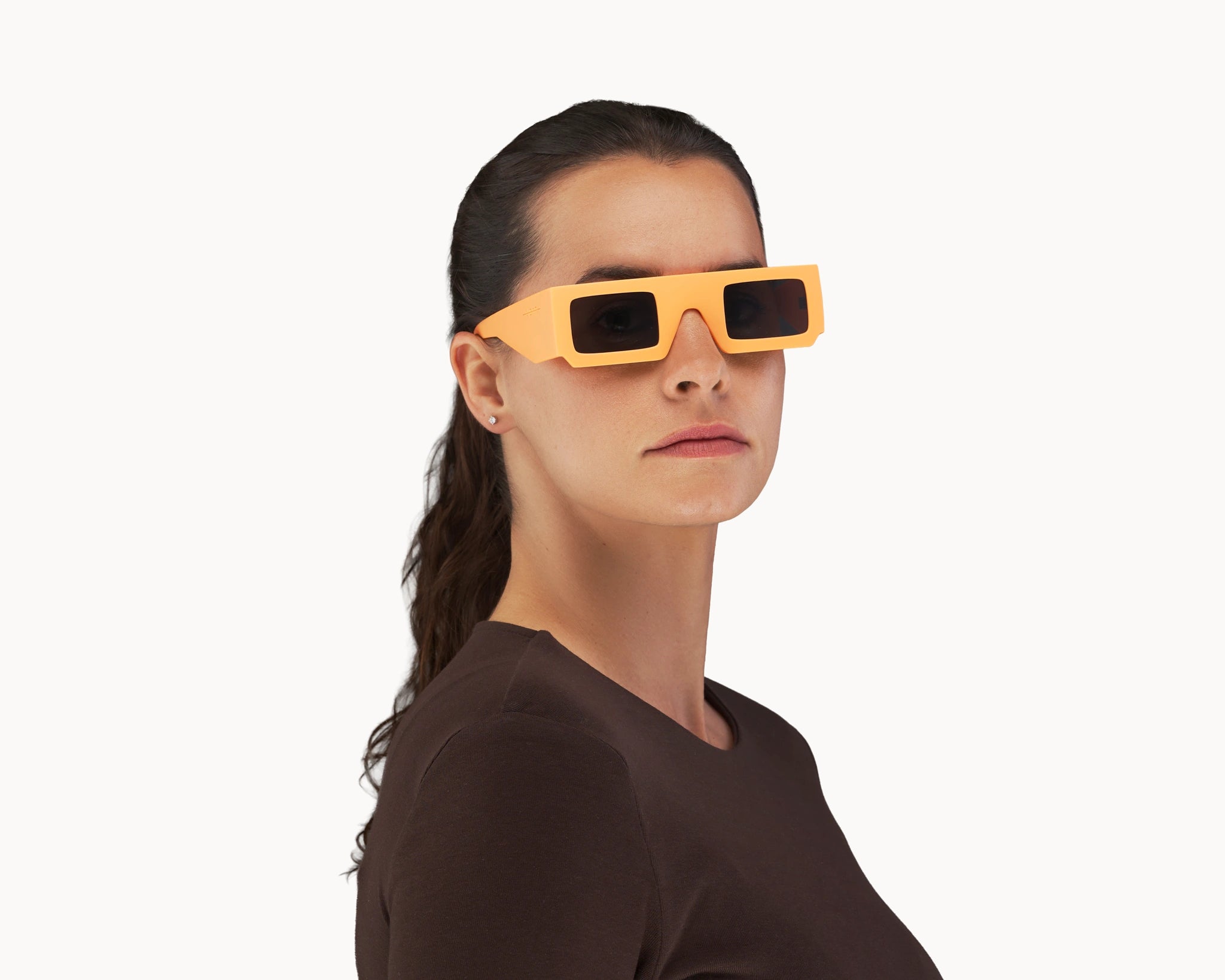 Kvinnelig modell med ikoniske 3D-inspirerte oransje retro-solbriller fra VIDAR EYEWEAR.