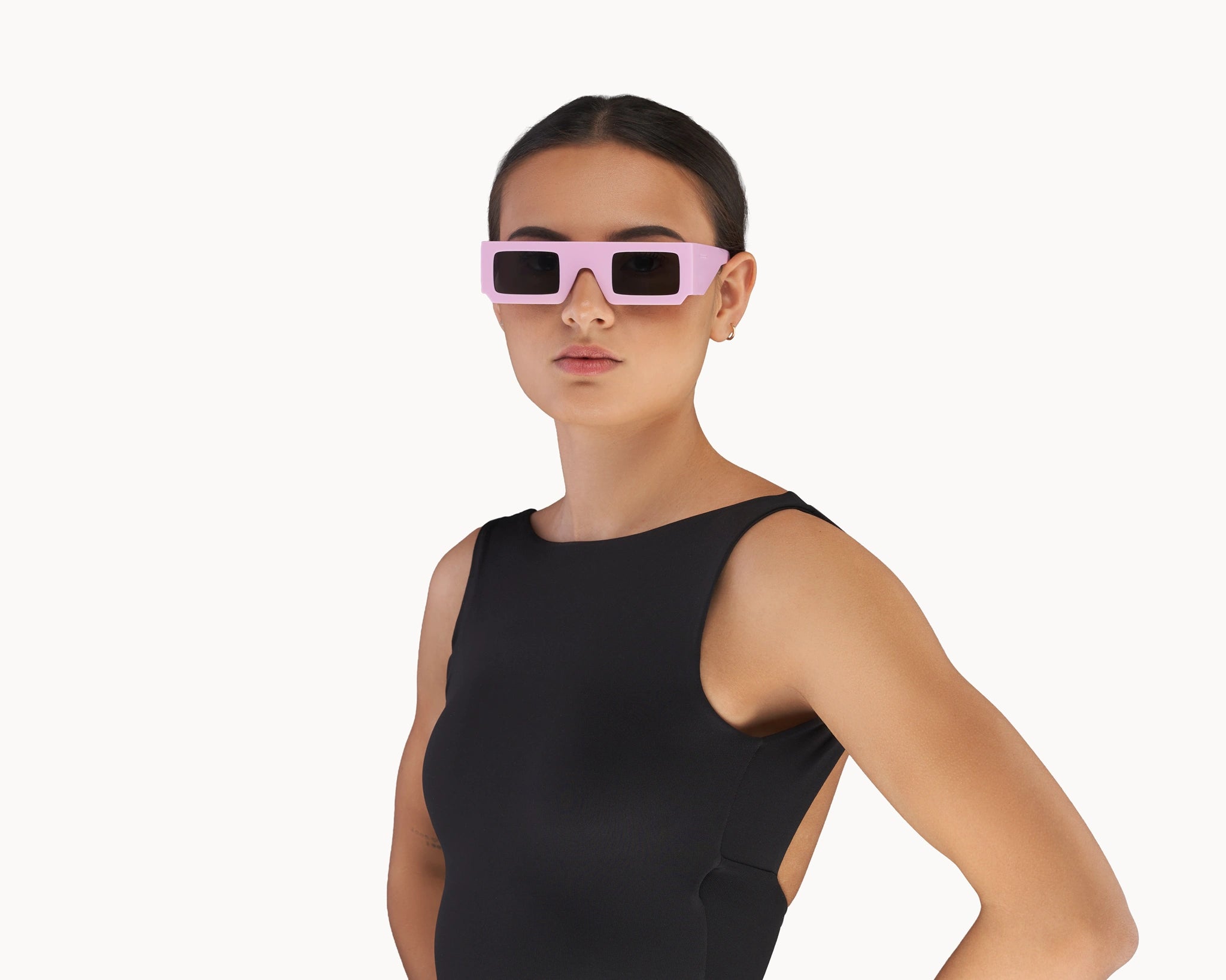 Kvinnelig modell med ikoniske 3D-inspirerte rosa retro-solbriller fra VIDAR EYEWEAR.